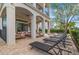 Covered patio with comfortable seating and views of lush landscaping, perfect for outdoor relaxation at 304 Muirfield Loop, Reunion, FL 34747