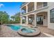 Gorgeous pool and spa with a brick-paved patio and a luxury home with columns and second-story balconies at 304 Muirfield Loop, Reunion, FL 34747