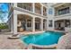 An inviting pool with a hot tub surrounded by a spacious patio and a multi-story house with balconies at 304 Muirfield Loop, Reunion, FL 34747