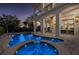 Backyard pool and spa with in-pool lighting and brick pavers, perfect for relaxing and entertaining at dusk at 304 Muirfield Loop, Reunion, FL 34747