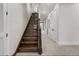Elegant staircase with hardwood steps and white risers leading to the upper level, enhanced by a neutral-toned hallway at 304 Muirfield Loop, Reunion, FL 34747