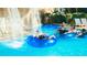 Relaxing in the lazy river surrounded by lush greenery and a scenic waterfall feature at 304 Muirfield Loop, Reunion, FL 34747