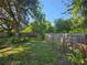 A spacious backyard featuring a wooden fence that ensures privacy with lush greenery and partial shade at 3055 Leflore Ln, Orlando, FL 32833