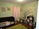 Playful bedroom with a whimsical tree mural and lots of soft, plush toys at 3055 Leflore Ln, Orlando, FL 32833