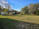 Expansive backyard with various sheds and structures surrounded by lush green trees at 306 W Palm St, Davenport, FL 33837