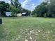 Large backyard featuring a well-maintained lawn, trees, and sheds, creating a serene outdoor space at 306 W Palm St, Davenport, FL 33837