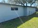 Side view of the home's exterior featuring a window and green lawn at 306 W Palm St, Davenport, FL 33837