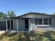 View of the front entry with storm door and covered patio at 306 W Palm St, Davenport, FL 33837