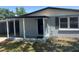 View of the front entry with storm door and covered patio at 306 W Palm St, Davenport, FL 33837