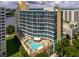 High-rise building with colorful facade, balconies, and a beautiful pool area with lounge seating at 322 E Central Blvd # 1612, Orlando, FL 32801