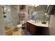 Bathroom featuring a walk-in shower with glass doors, neutral tile, and a single vanity at 3338 Robert Trent Jones Dr # 30704, Orlando, FL 32835