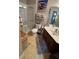 Bright bathroom featuring a shower, vanity with modern fixtures and a colorful South Beach-themed art piece at 3338 Robert Trent Jones Dr # 30704, Orlando, FL 32835