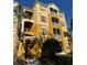Condo building with yellow facade, wood shutters, multiple balconies, and lush green landscaping at 3338 Robert Trent Jones Dr # 30704, Orlando, FL 32835