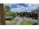 Scenic view from a screened lanai shows the parking area with pond and lush landscaping beyond at 3338 Robert Trent Jones Dr # 30704, Orlando, FL 32835