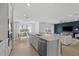 Open-concept kitchen with island seating, stainless steel appliances, and a view into the living room at 3406 Haven Side Rd, Davenport, FL 33837