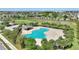 The aerial view shows the community pool offers a kidney shape, lounge chairs, shelter, palm trees, and manicured landscaping at 372 Willet St, Haines City, FL 33844