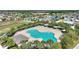 An aerial view of the community pool with an inviting kidney shape, surrounded by palm trees and well-manicured green landscaping at 372 Willet St, Haines City, FL 33844