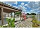 Landscaped backyard with covered pergola and paved pathway at 372 Willet St, Haines City, FL 33844