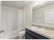 A bathroom with a single sink vanity, tile flooring, and a shower with white tile surround at 372 Willet St, Haines City, FL 33844