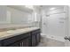 Bathroom featuring double sinks, dark cabinetry, and a glass-enclosed shower at 372 Willet St, Haines City, FL 33844