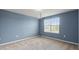 Bedroom featuring blue walls, neutral carpet, a modern light fixture, and a window providing natural light at 372 Willet St, Haines City, FL 33844