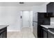 View of the stainless steel refrigerator, dark cabinets, and tile flooring at 372 Willet St, Haines City, FL 33844