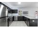 Modern kitchen with stainless steel appliances, granite countertops, and dark cabinets at 372 Willet St, Haines City, FL 33844