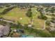 Aerial view of a vibrant community featuring lush green golf course, homes, and mature trees at 3843 Beacon Ridge Way, Clermont, FL 34711