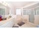 Bright bathroom featuring double sinks, a soaking tub, and a separate glass-enclosed shower at 3843 Beacon Ridge Way, Clermont, FL 34711