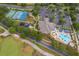 Aerial shot of community amenities featuring a playground, pool, tennis courts, and clubhouse, promoting active living at 3843 Beacon Ridge Way, Clermont, FL 34711