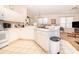 Bright kitchen with white cabinets, modern appliances, and a view to a dining area at 3843 Beacon Ridge Way, Clermont, FL 34711