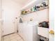 Bright laundry room equipped with a washer, dryer, shelving, and utility sink for efficient home management at 3843 Beacon Ridge Way, Clermont, FL 34711