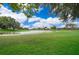 Picturesque view of a pond surrounded by a well-manicured lawn, adding natural beauty and tranquility at 3843 Beacon Ridge Way, Clermont, FL 34711