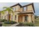 Charming two-story townhome featuring warm tones, shutters, a well-maintained front yard, and a welcoming entryway at 4031 Calabria Avenue, Davenport, FL 33897