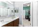 Bathroom featuring double sinks, a large mirror, vanity, and a doorway into an adjacent room at 420 Tulipwood Ln, Chuluota, FL 32766