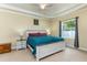 Bright bedroom with a tray ceiling, ceiling fan, window with curtains, and a bed with a white wood frame at 420 Tulipwood Ln, Chuluota, FL 32766