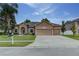 Home with a three car garage, well-manicured lawn, and fresh landscaping at 420 Tulipwood Ln, Chuluota, FL 32766