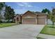 Home with a three car garage, well-manicured lawn, and mature tree at 420 Tulipwood Ln, Chuluota, FL 32766