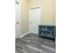 Hallway with wood flooring, grey cabinet with glass doors, and white doors at 420 Tulipwood Ln, Chuluota, FL 32766