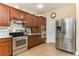 Well-equipped kitchen with stainless steel appliances and wood cabinetry at 420 Tulipwood Ln, Chuluota, FL 32766