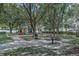 Community playground featuring swings, climbing equipment, park benches, and picnic tables at 420 Tulipwood Ln, Chuluota, FL 32766