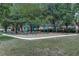 Community playground area with multiple swings, slides, benches, and mature shady trees at 420 Tulipwood Ln, Chuluota, FL 32766