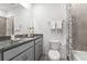 Modern bathroom with gray cabinets, granite countertops, and a shower-tub combo at 502 Belmond Dr, Debary, FL 32713
