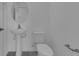 A minimalist bathroom with a pedestal sink, toilet, and simple fixtures in a neutral color palette at 502 Belmond Dr, Debary, FL 32713