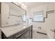 Elegant bathroom featuring a marble countertop, black vanity, and classic white tile with black trim at 504 W Faith Ter, Maitland, FL 32751