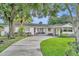 Inviting single-story home featuring a pink door, covered porch, and a spacious driveway at 504 W Faith Ter, Maitland, FL 32751
