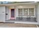 Charming front porch with decorative ironwork, a pink door, and seating, offering a welcoming curb appeal at 504 W Faith Ter, Maitland, FL 32751