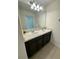Bathroom vanity featuring double sinks, ample counter space, and a large mirror for convenience at 5054 Tibet Ct, St Cloud, FL 34772