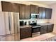 Modern kitchen with stainless steel appliances, subway tile backsplash, and dark cabinets at 5054 Tibet Ct, St Cloud, FL 34772