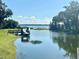 Scenic lake view showcasing a private dock, lush trees, and calm water at 5054 Tibet Ct, St Cloud, FL 34772